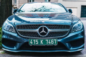 Mercedes avec une plaque d’immatriculation diplomatique verte et blanche garée dans la rue.